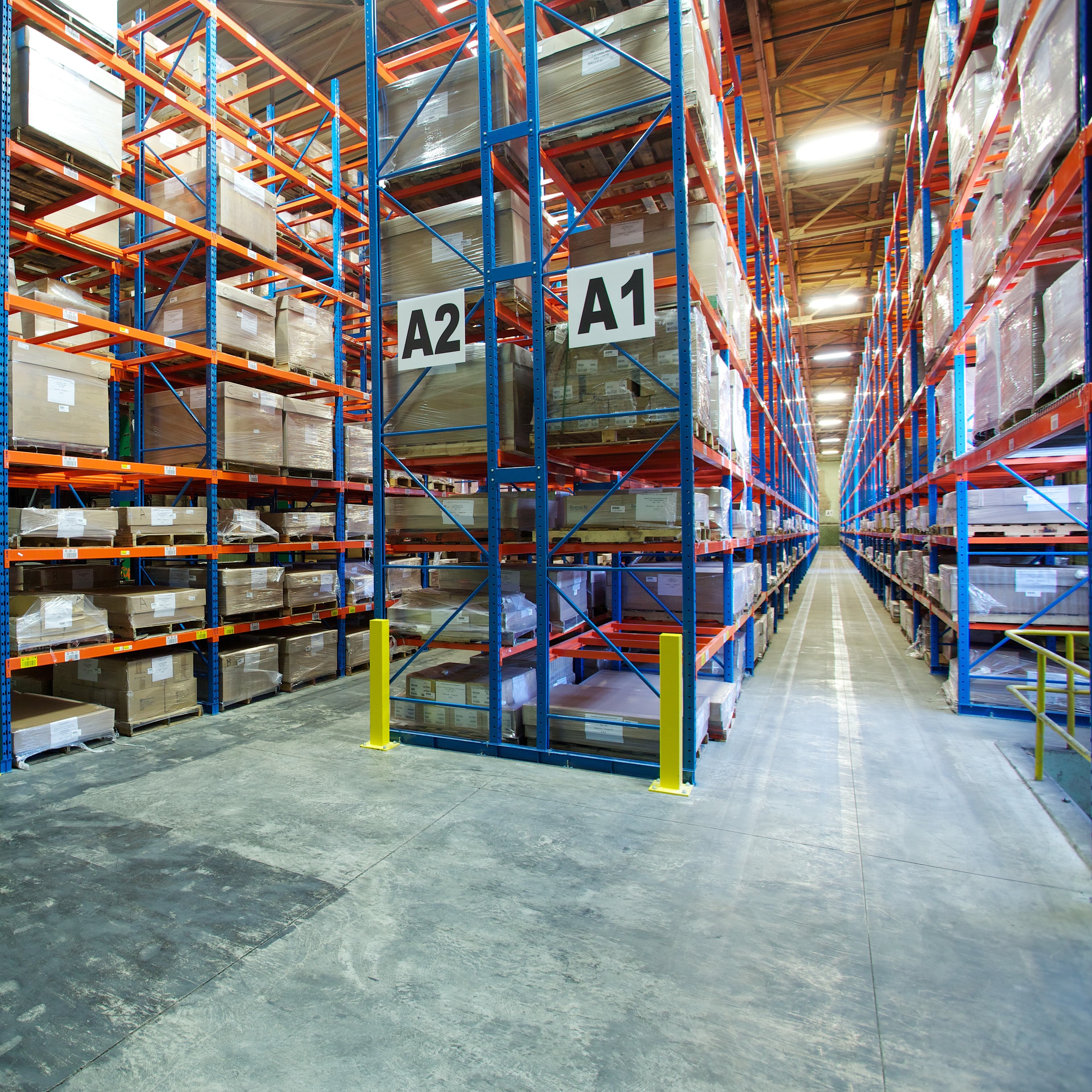 What We Offer - Image 3 "Forklift moving large pallets of books in a warehouse."