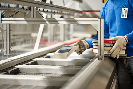 Worker sorting books on sorter conveyer