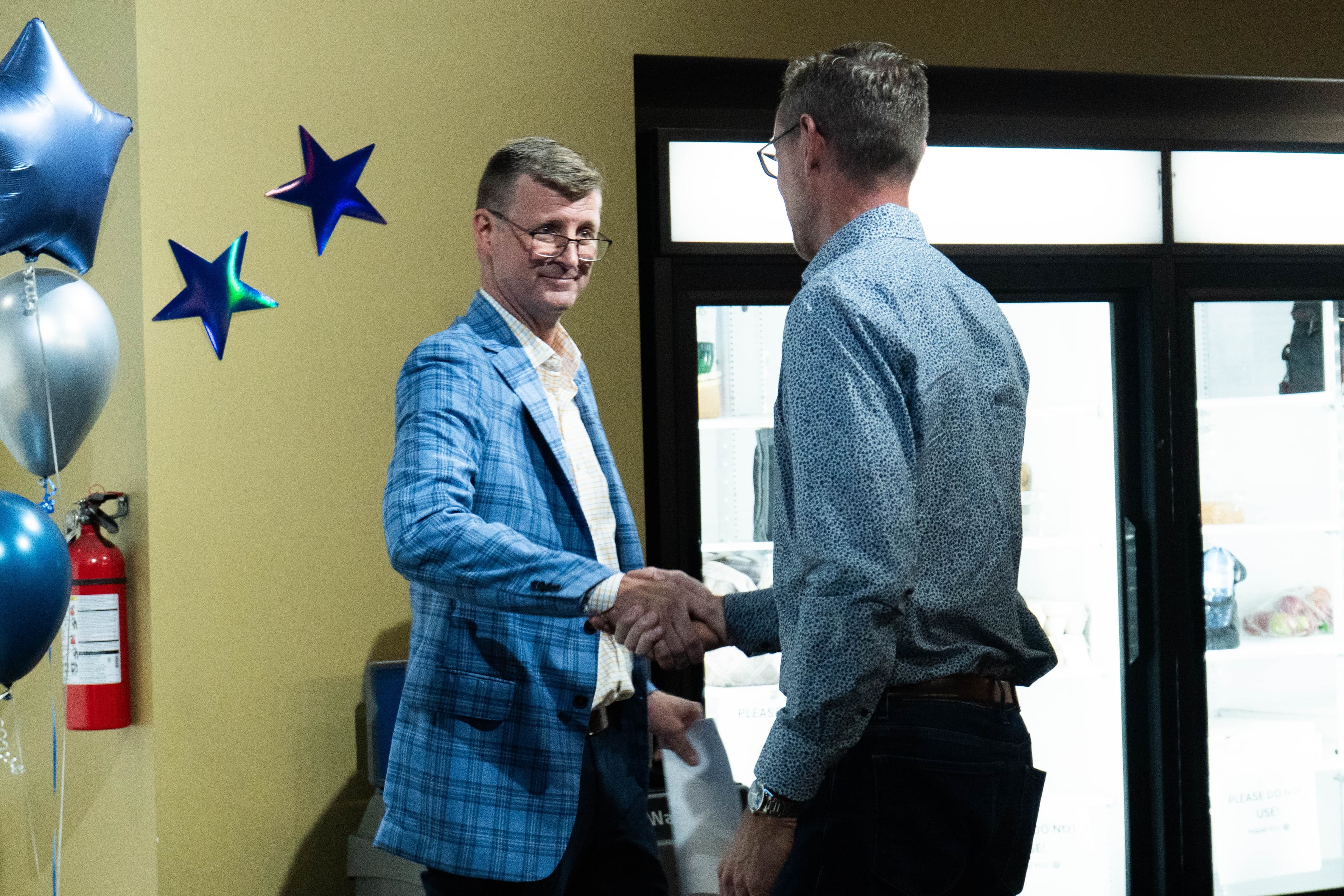 Wilf and Pat shake hands at Wilf's anniversary party