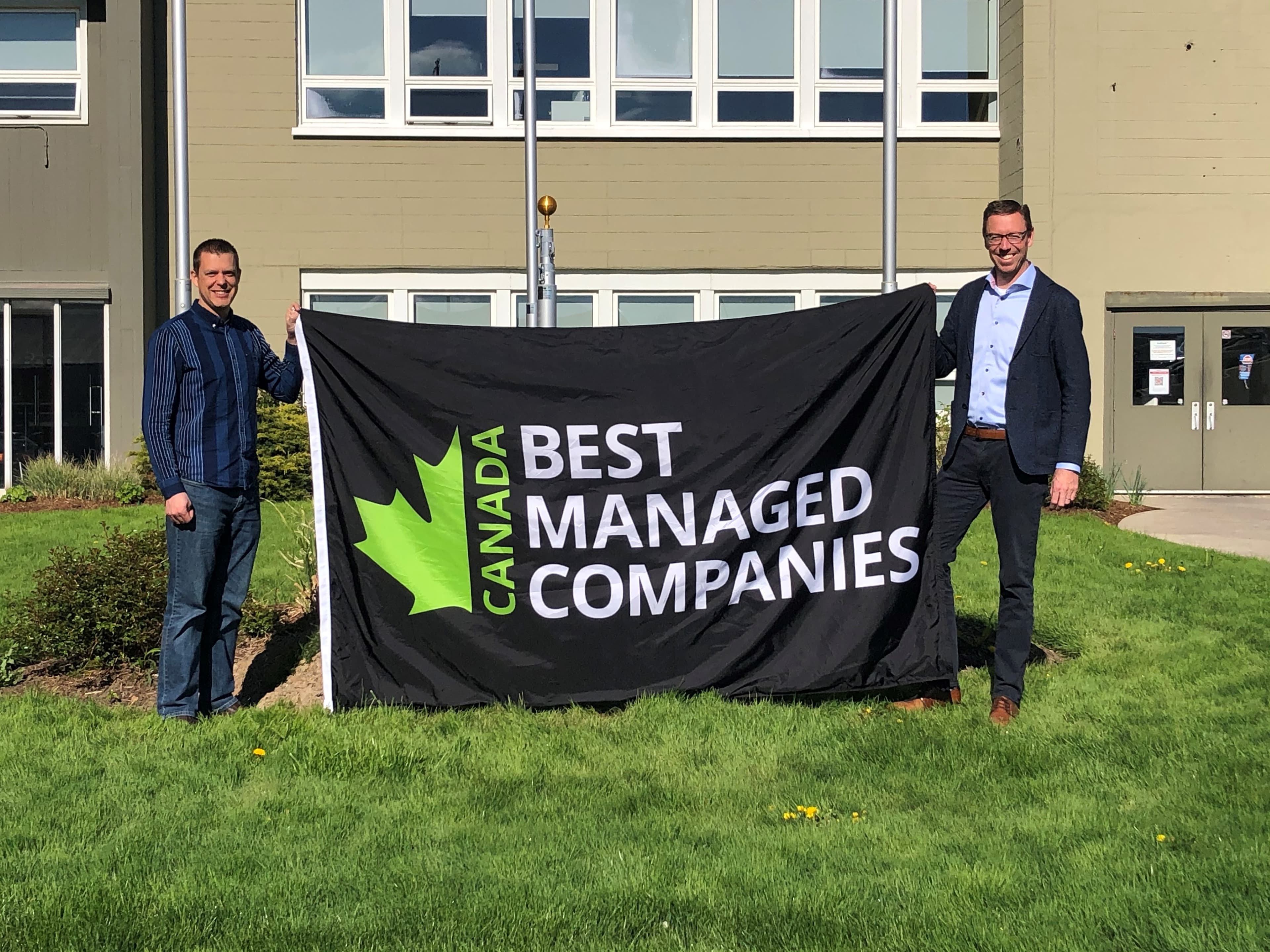 Wilf and Derek holding the Canada Best Managed Companies flag